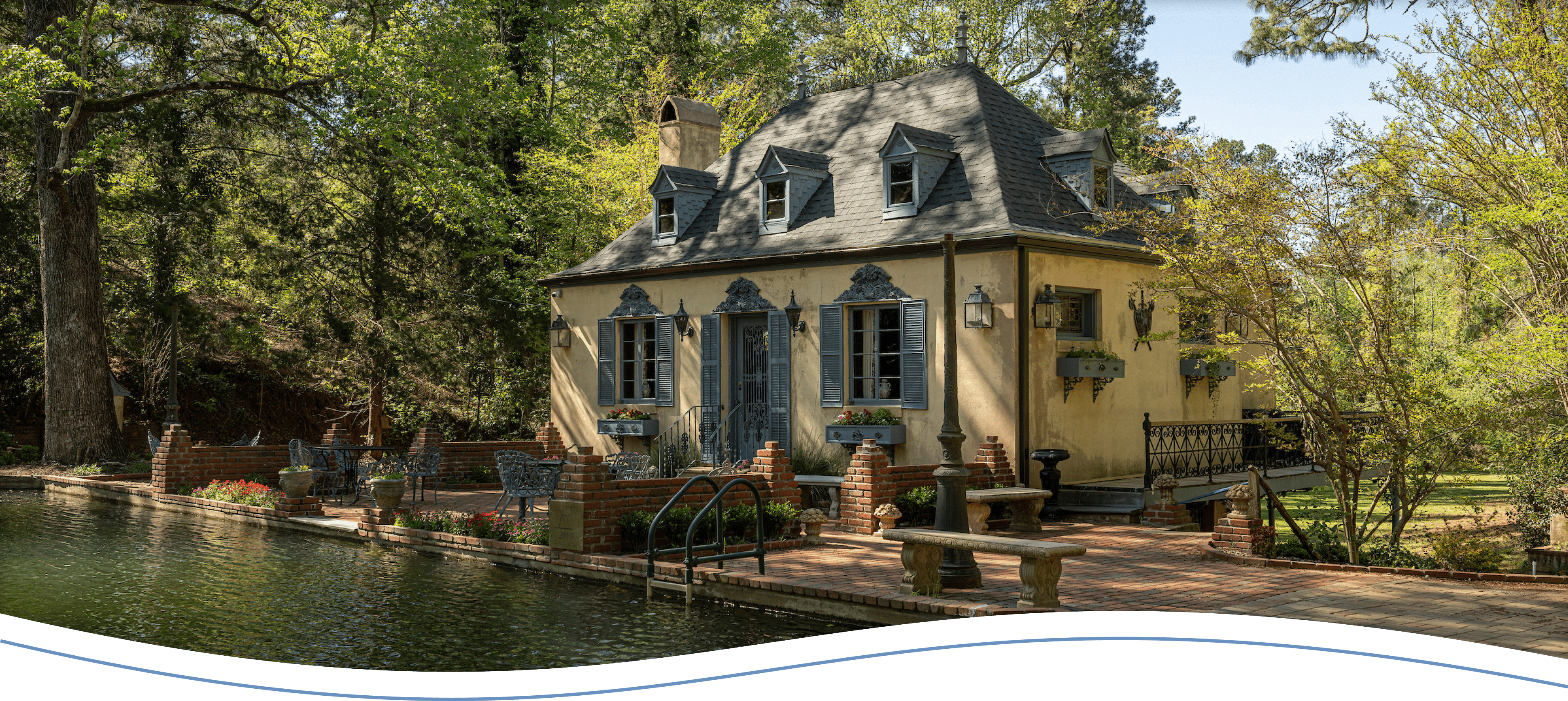 An old mansion with a swimming pool in front of it