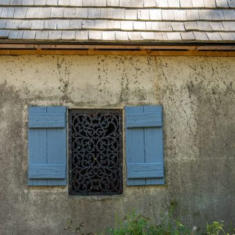 A window with shutters and a metal grill.