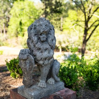 A statue of a lion sitting on top of a stone.