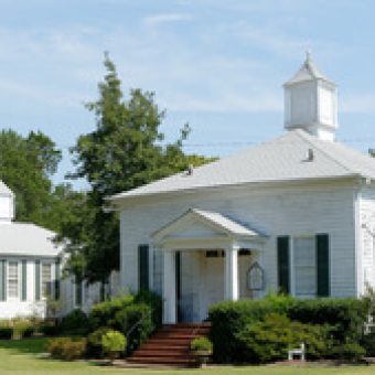 A white church with two smaller ones in the background.