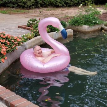 A person in the water on an inflatable flamingo.