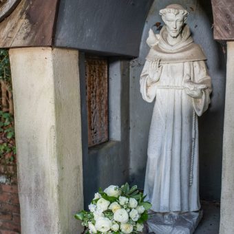 A statue of st. Francis and flowers in the courtyard