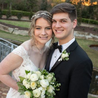 A young couple posing for a picture at their wedding.