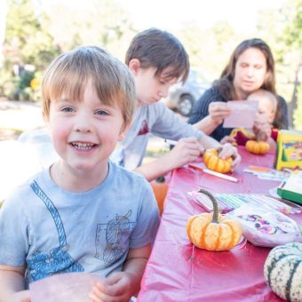 A group of children sitting at a table with pumpkins.