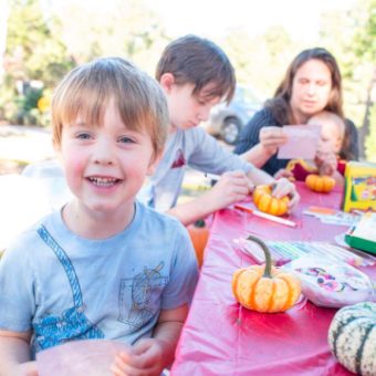 A group of children sitting at a table with pumpkins.
